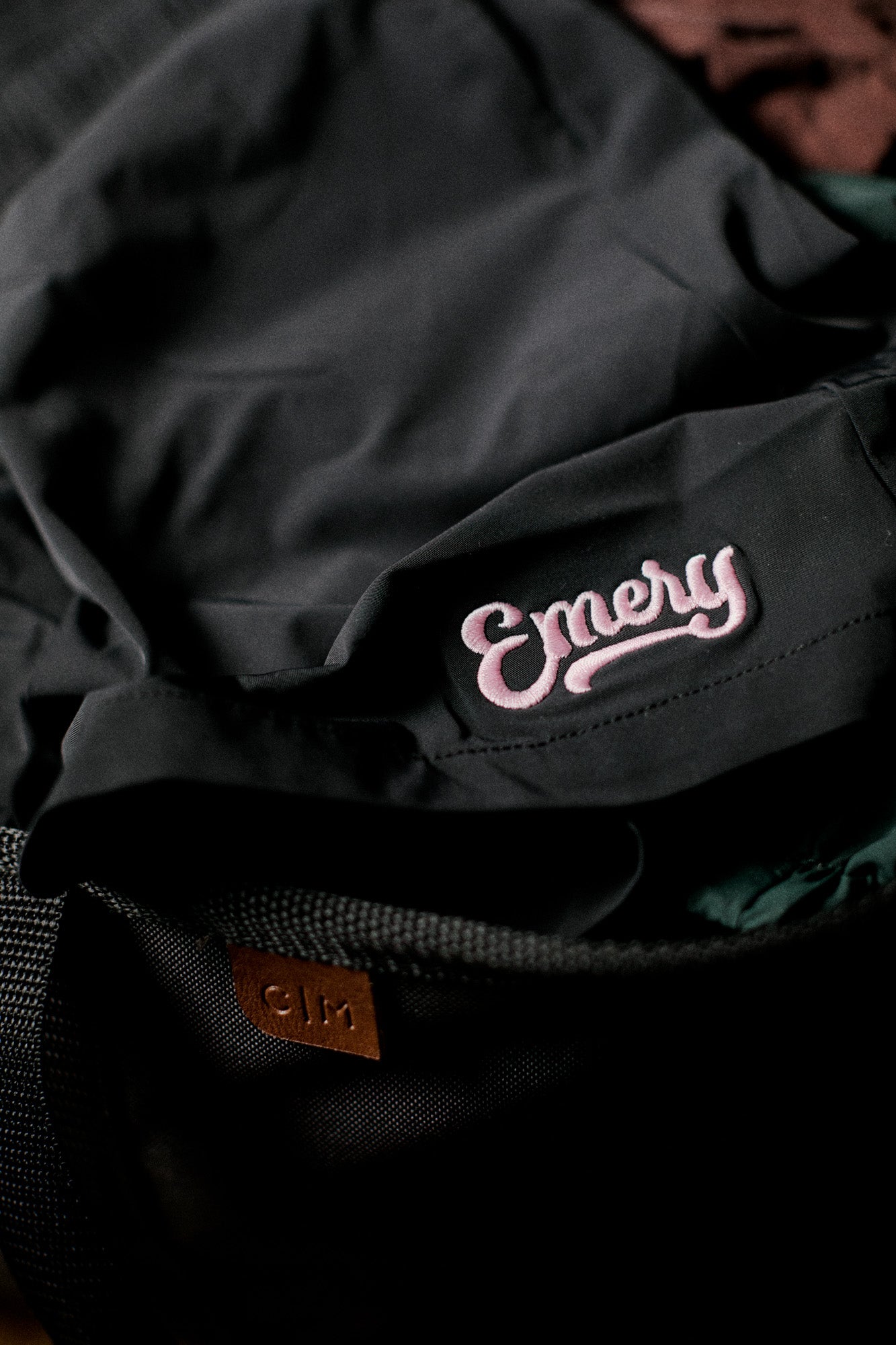 Black backpack with 'Emery' branding on a dark background