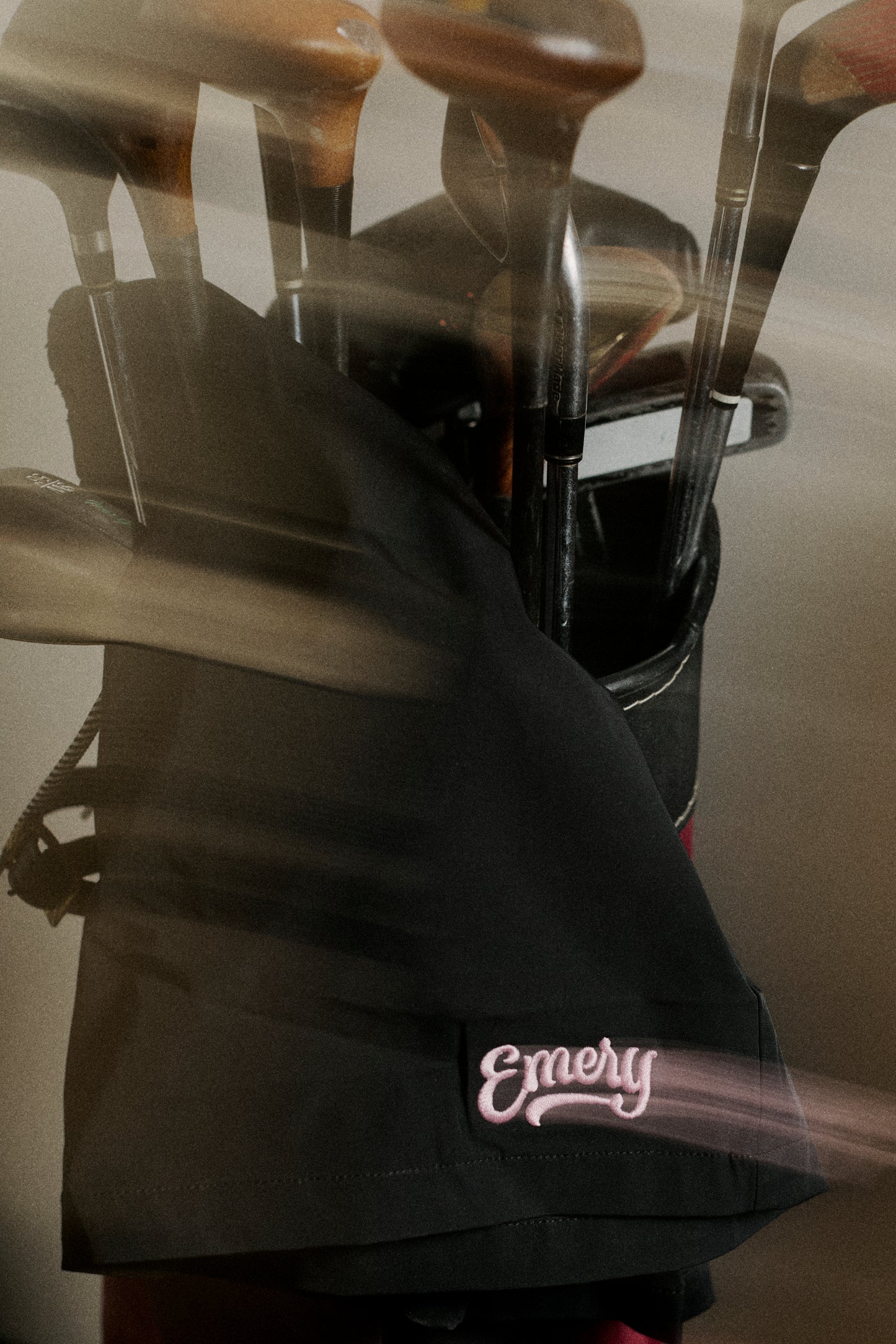 Golf bag with golf clubs and 'Emery' branding on a blurred background