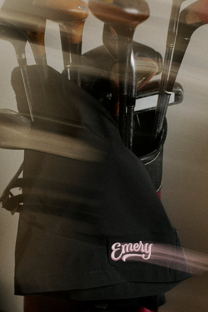 Golf bag with golf clubs and 'Emery' branding on a blurred background